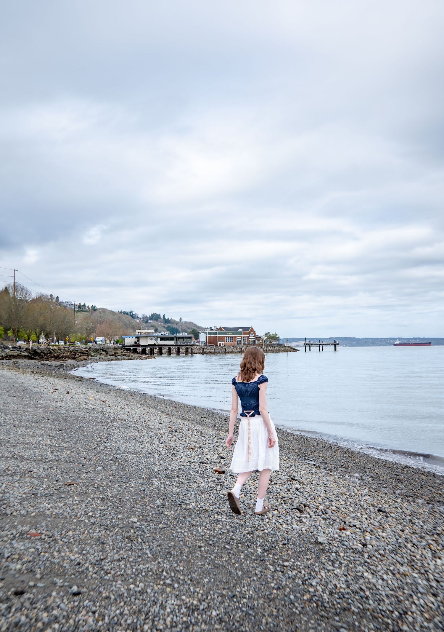 High school senior walking along beach at Tacoma waterfront park