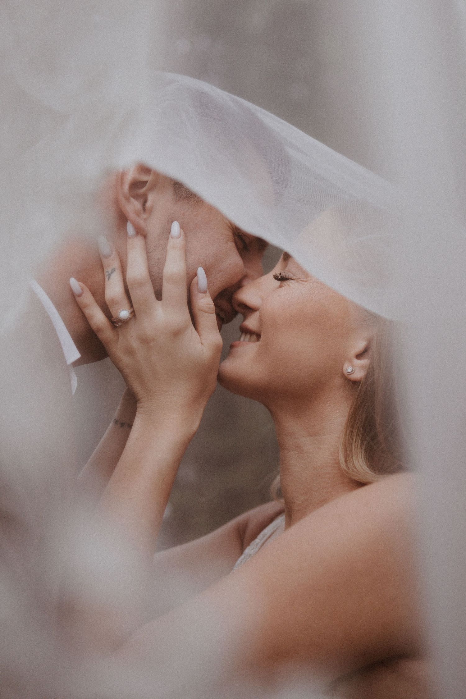 Romantický detail nevesty a ženícha pod jemným závojom s dôrazom na zásnubný prsteň. Profesionálny svadobný fotograf Rajecké Teplice.