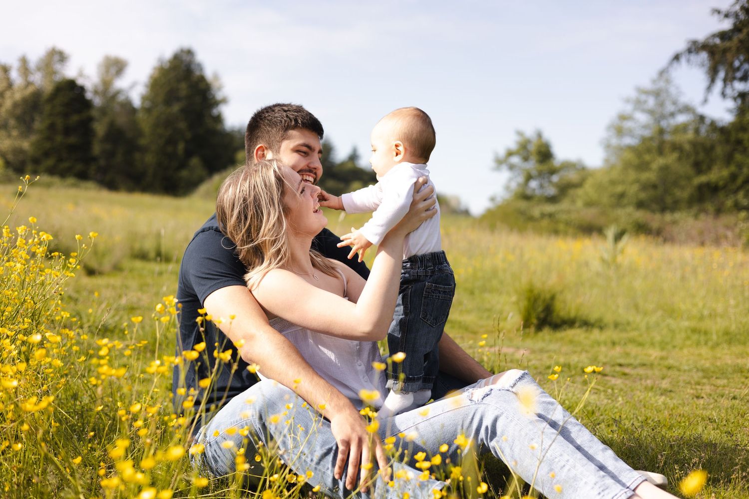 Family photoshoot in a meadow filled with yellow wildflowers during springtime in Bellingham, WA.