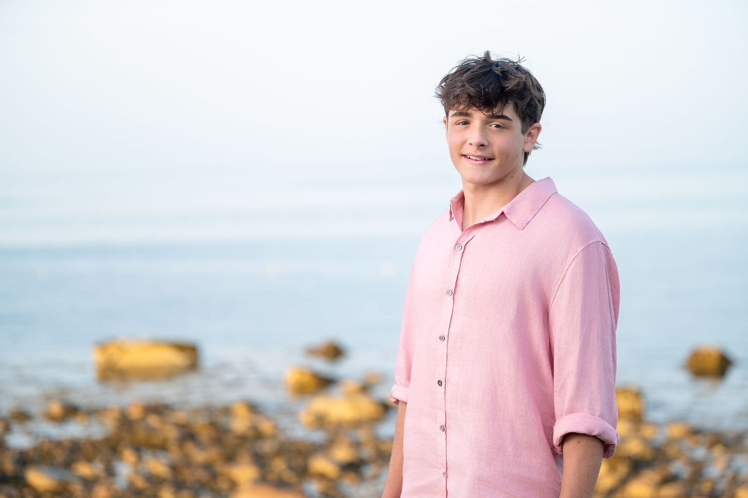 Person in pink button-down shirt poses against blurred outdoor background in a series of casual portraits.