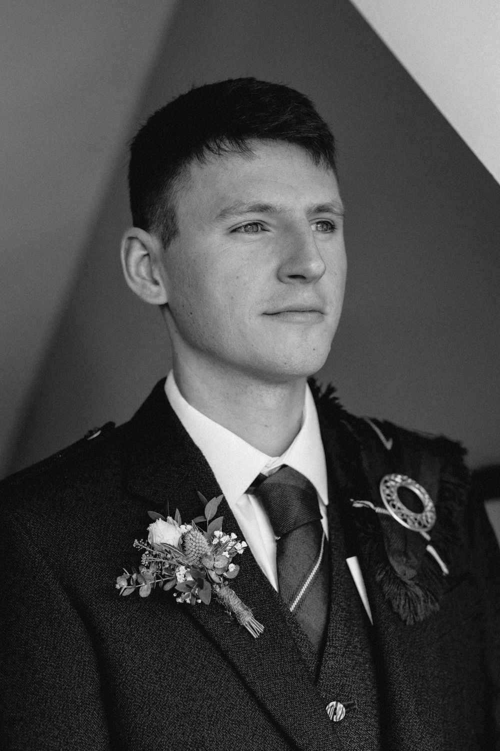 Black and white portrait series showing a person in formal attire with boutonniere from different angles.