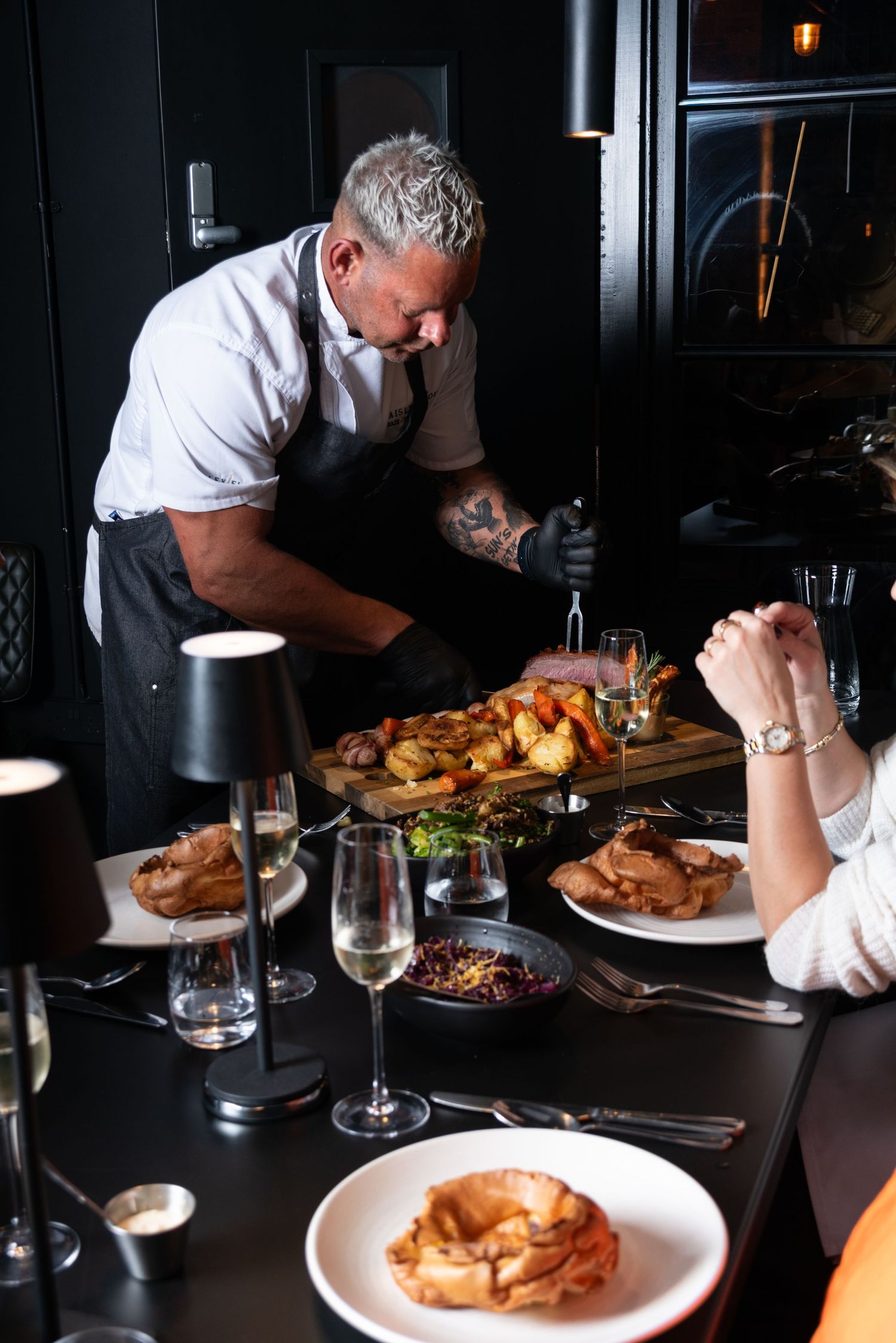 Chef carving Sunday roast at restaurant table, professional food and restaurant photography showcasing dining experience