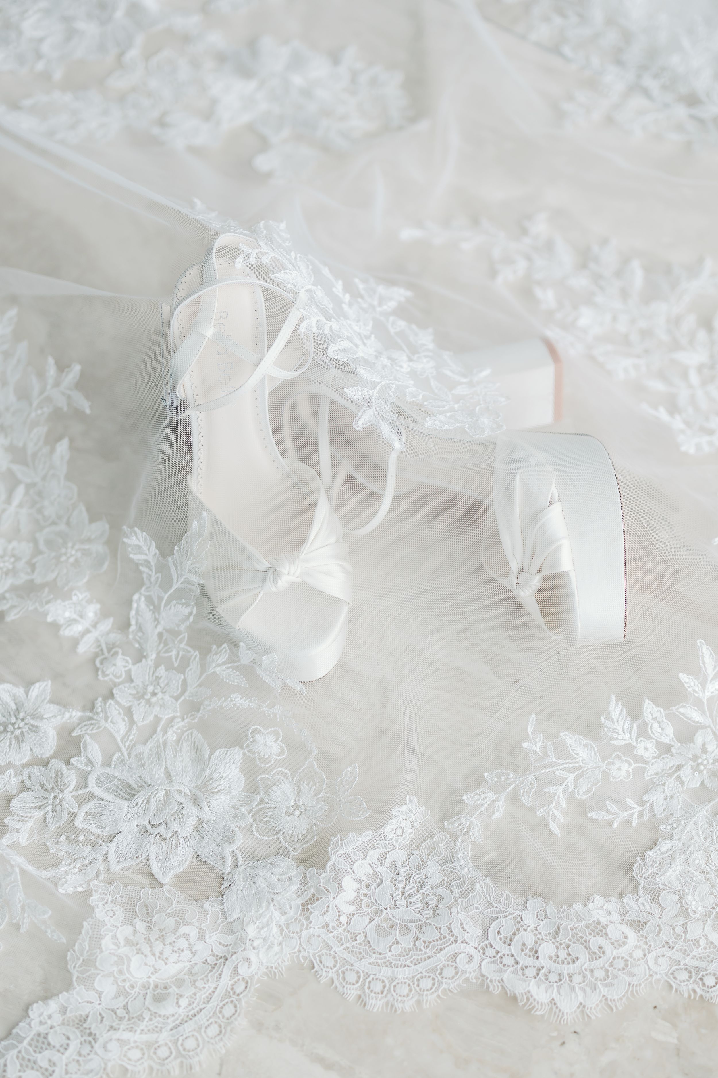 An assortment of wedding invitation elements, including flowers and a ring, on a light background.