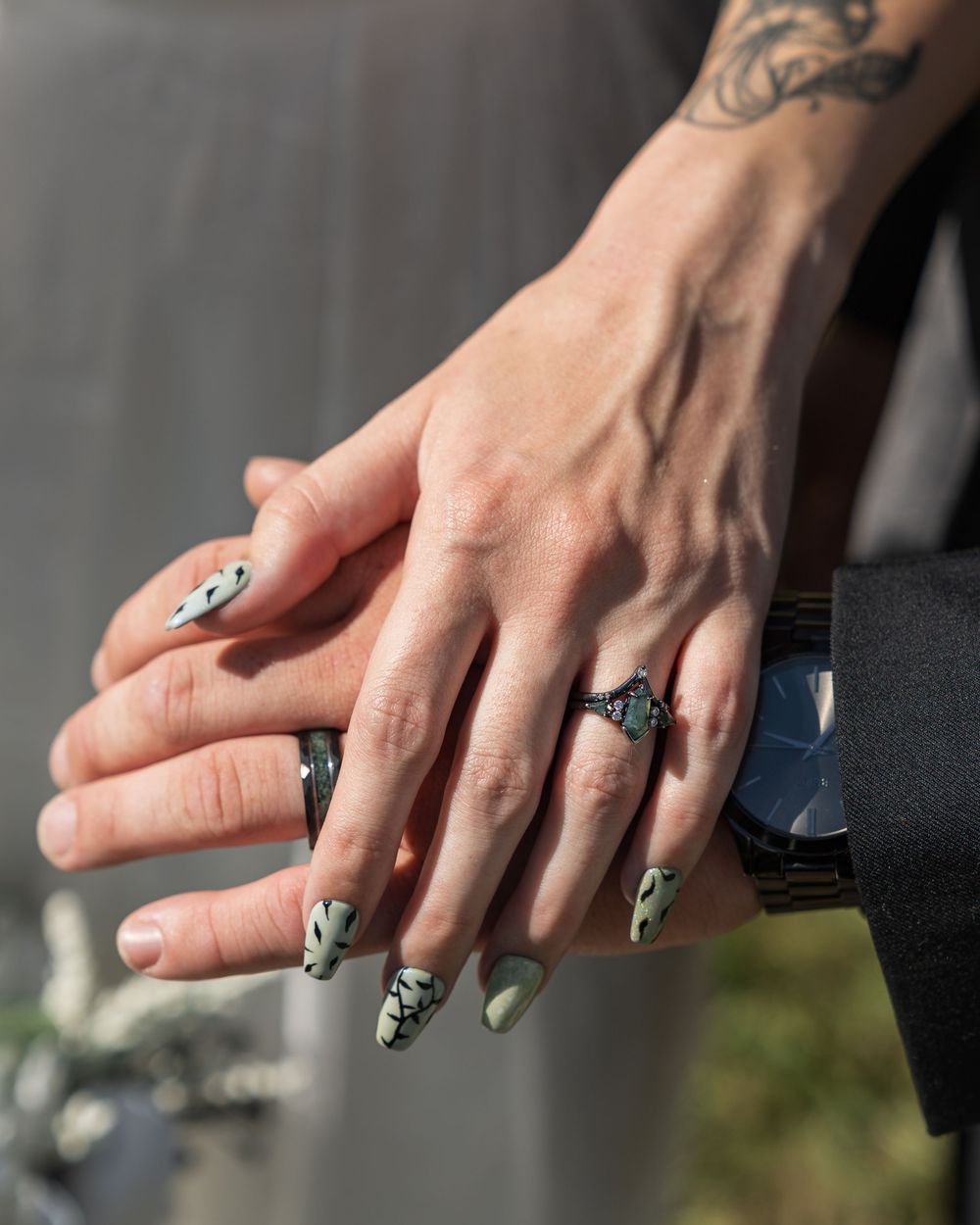 Close-up view of hands with black and white geometric nail art designs on long acrylic nails.