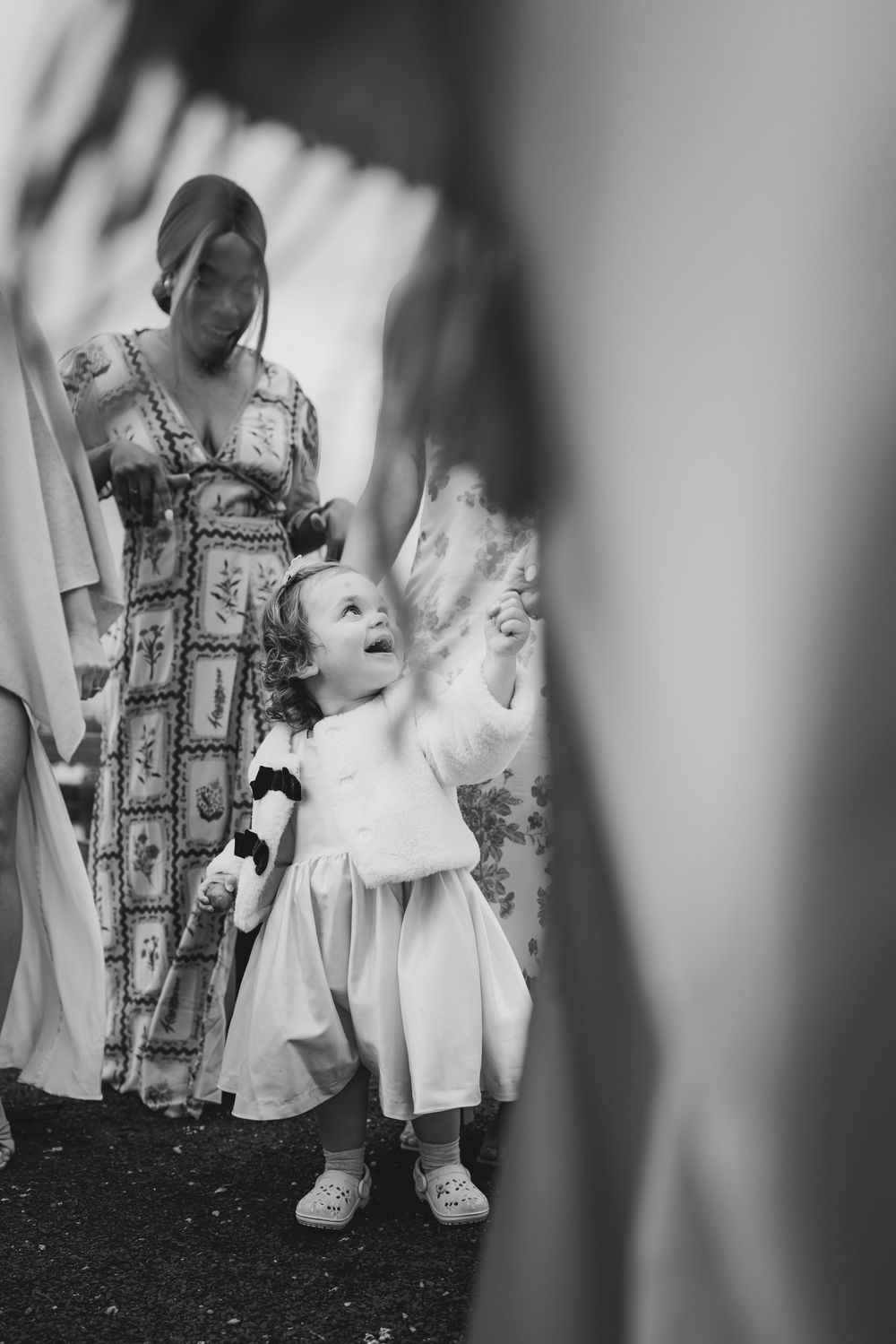 Black and white photo series showing a child in a white dress playing and twirling in motion.