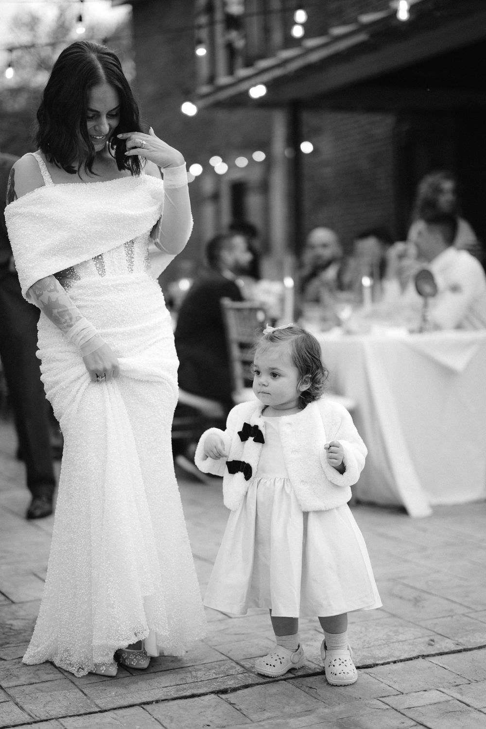 A series of black and white photos showing small children in white dresses at a formal event.