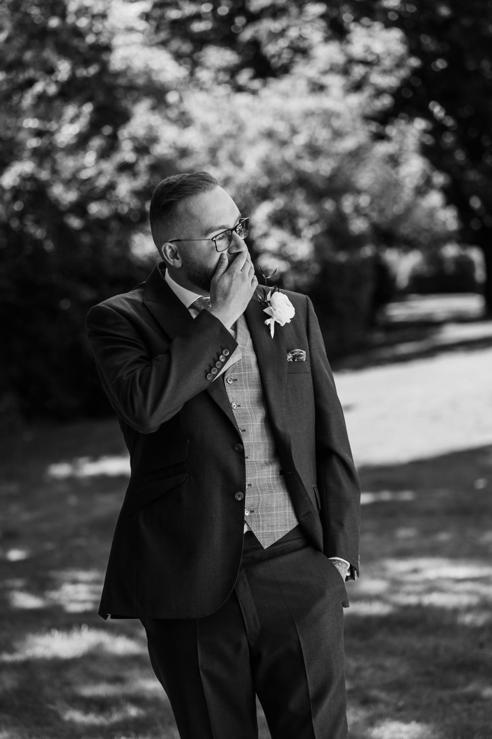 A black and white photo series showing emotional reactions of someone in a suit and glasses outdoors.