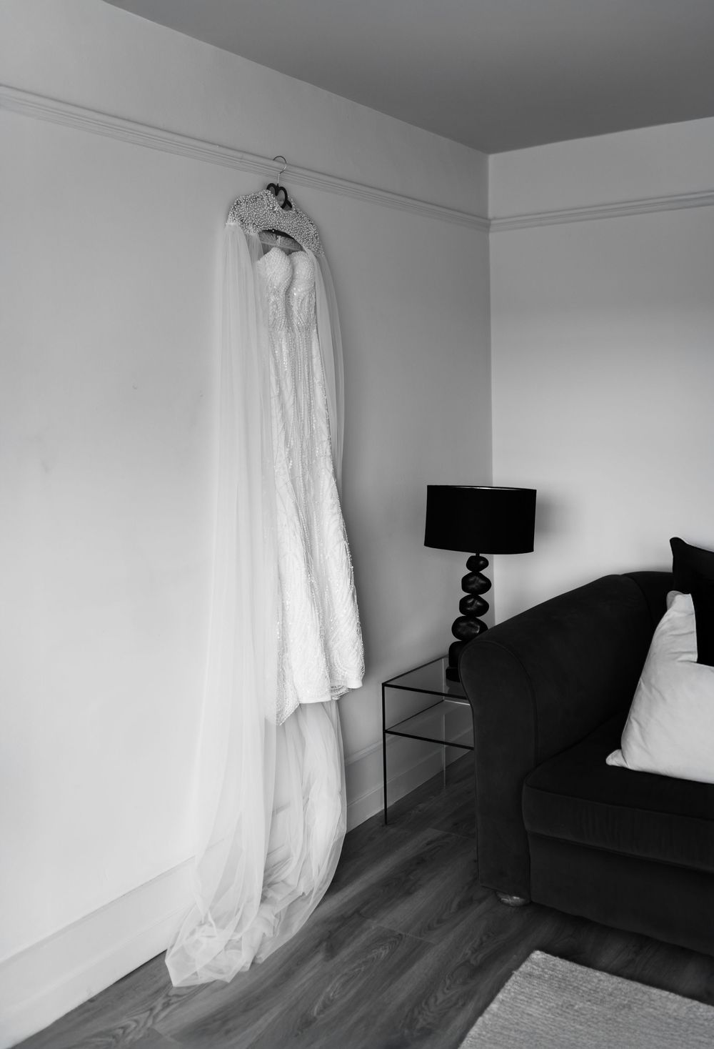 A sequence of black and white photos showing a ghostly white curtain moving in a dark room with hardwood floors.