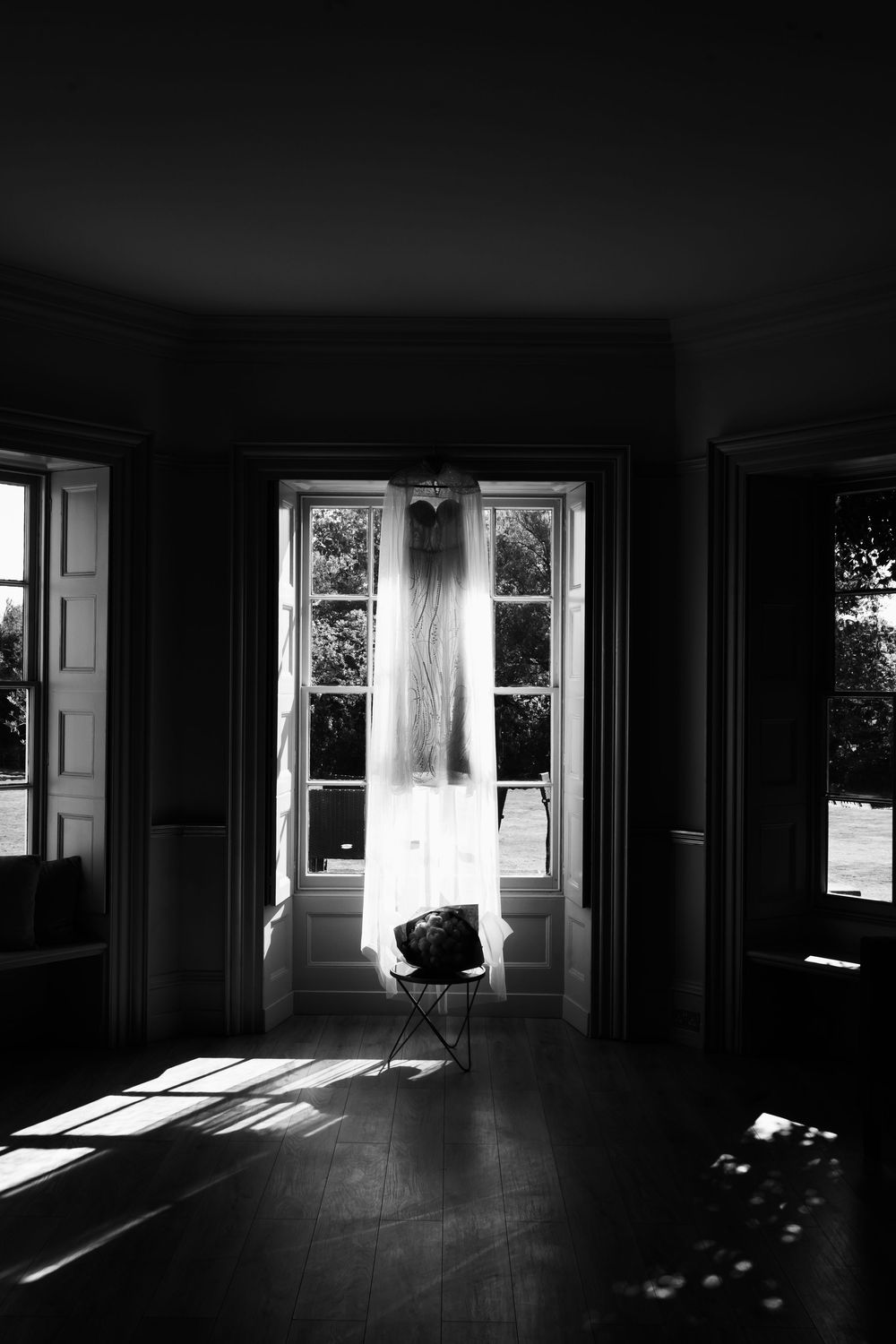 Dramatic black and white interior shots showing sunlight streaming through windows creating stark shadows on empty floors.