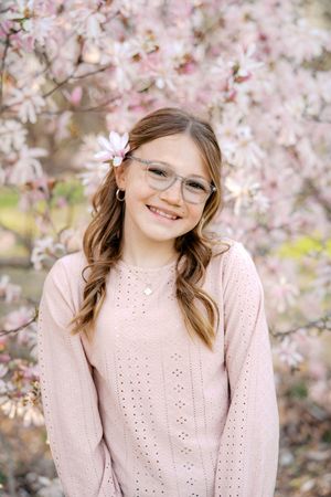 A series of cheerful portraits with pink magnolia blossoms in the background.