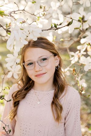 A series of portraits captured among blooming white magnolia or cherry blossoms in springtime.