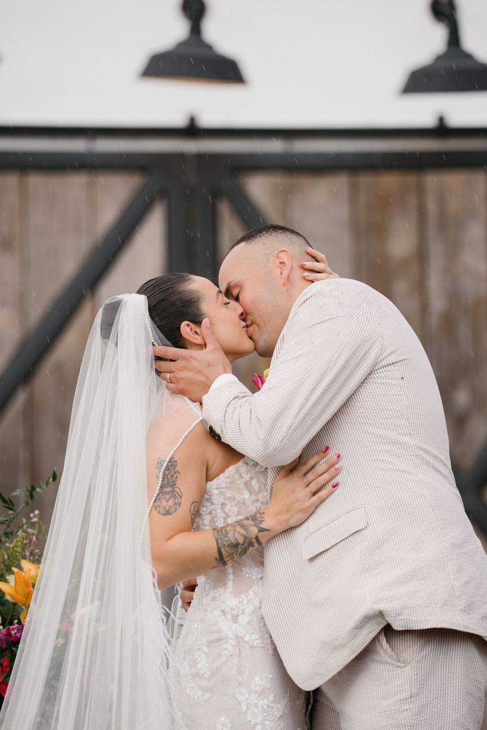 A romantic wedding couple shares intimate kisses in a sequence of four outdoor photos with a rustic backdrop.