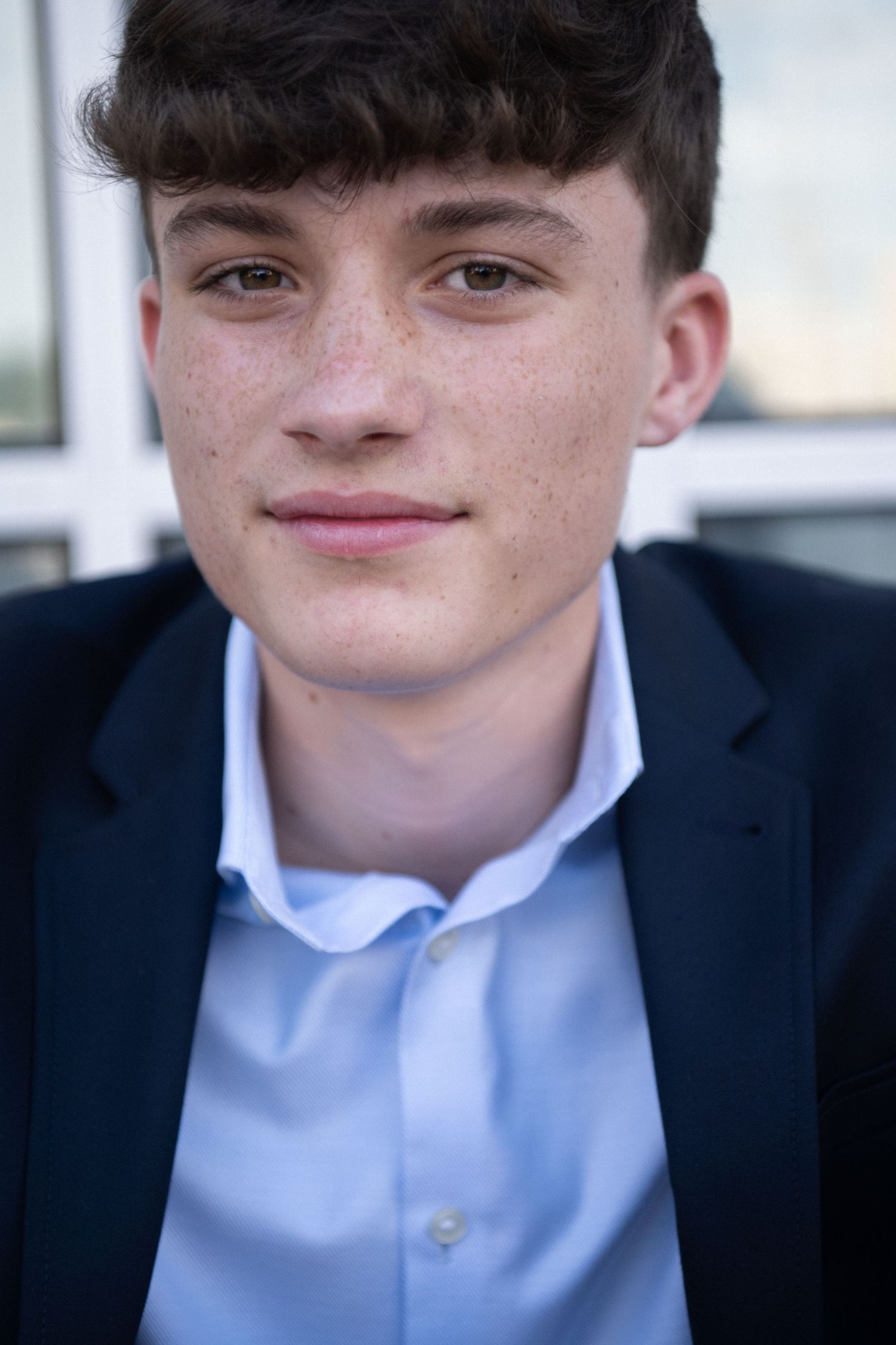 A series of five close-up photos showing someone in a navy suit jacket and light blue dress shirt.