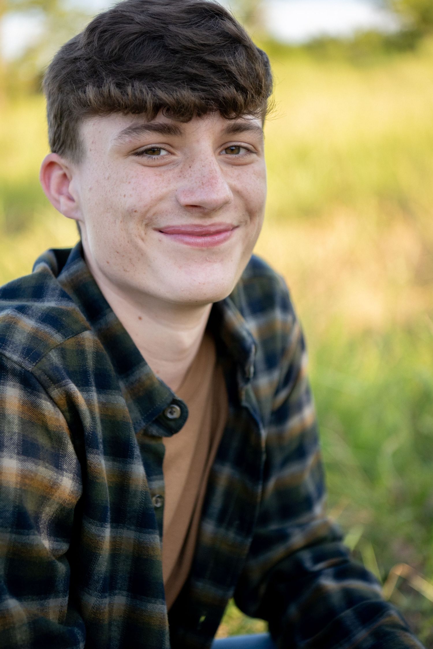 A series of outdoor portrait shots showing someone in a plaid flannel shirt against a soft golden natural background.