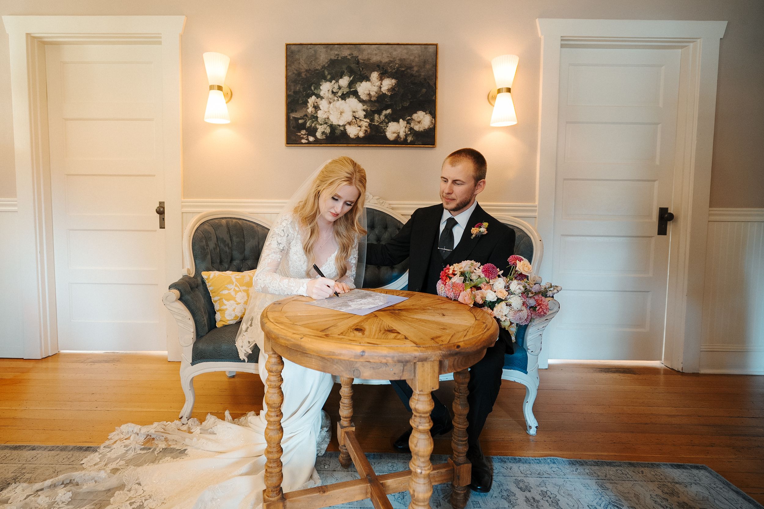 A series of elegant wedding photos showing romantic moments in a bright white room with wall sconces and wood floors.