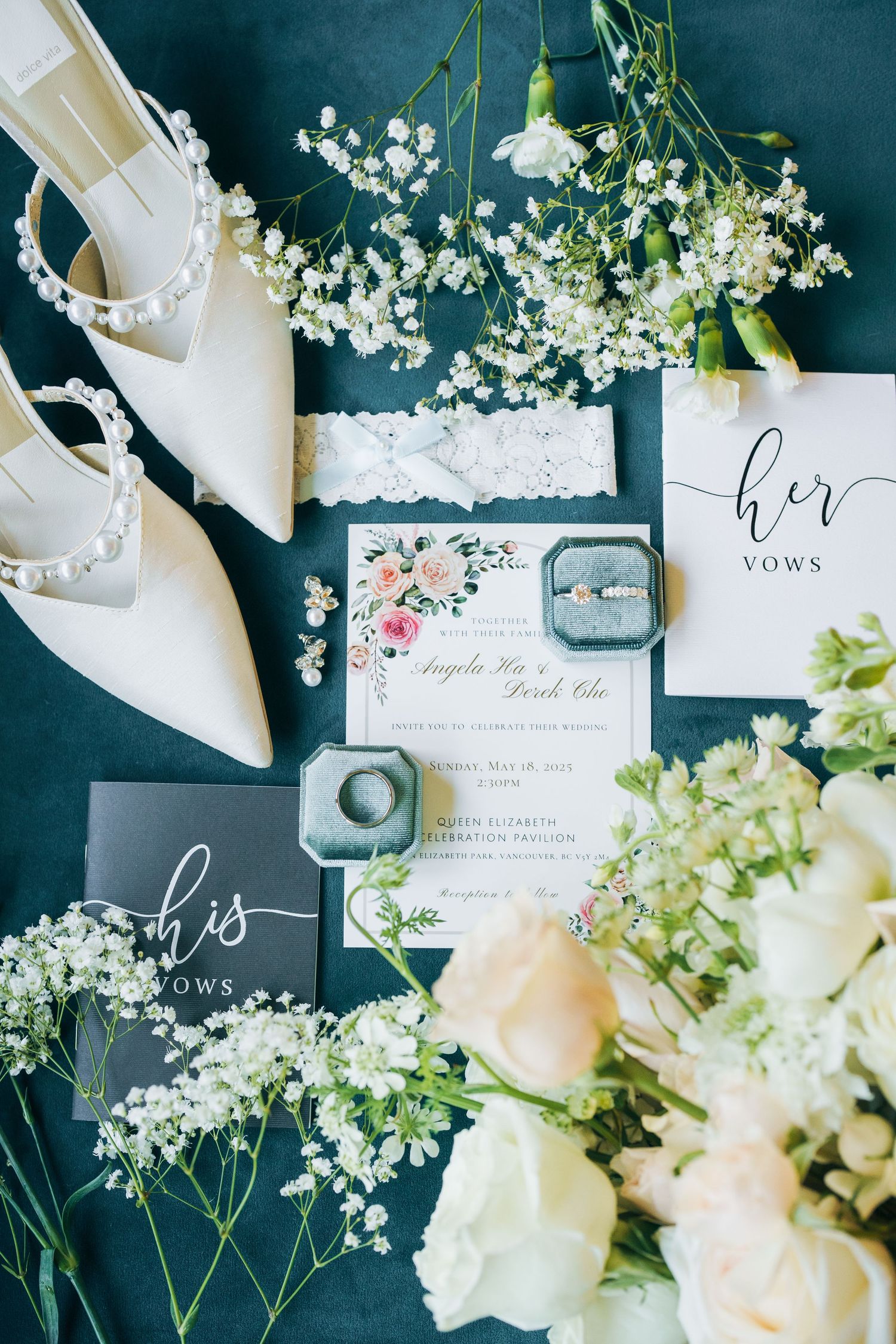 Wedding invitation suite with delicate white flowers and calligraphy on dark navy background with elegant styling details.