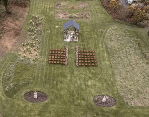 Aerial view of a garden with lattice trellises and circular planting beds in a grassy area.