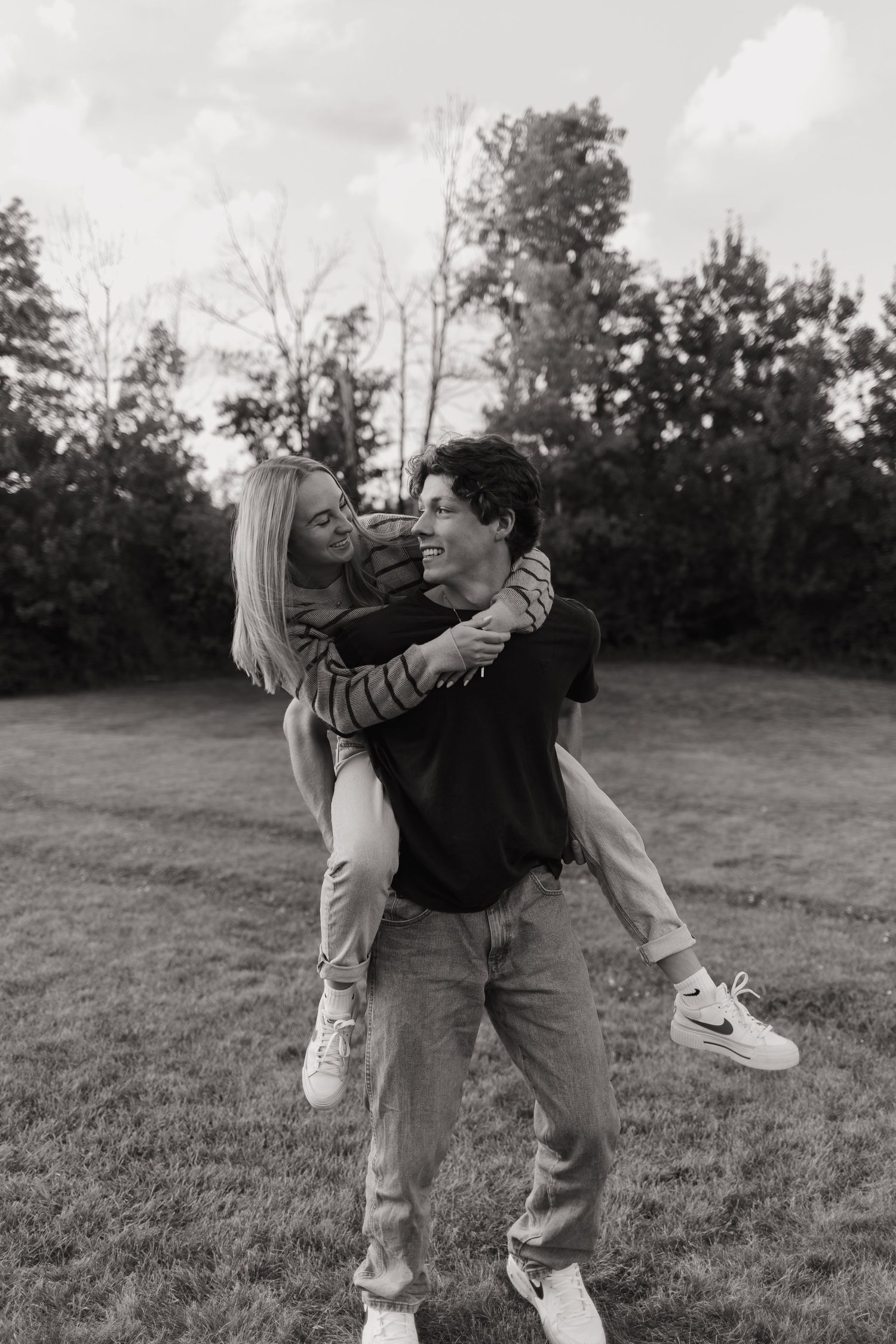 Husband kissing wife's cheek in a Wisconsin field during maternity session.