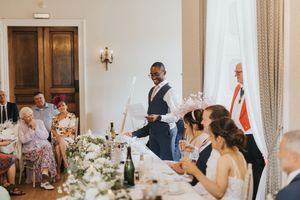 Wedding guests enjoy a reception dinner while staff serves at an elegant indoor venue at Cave Castle - taken by Grimsby photographer.