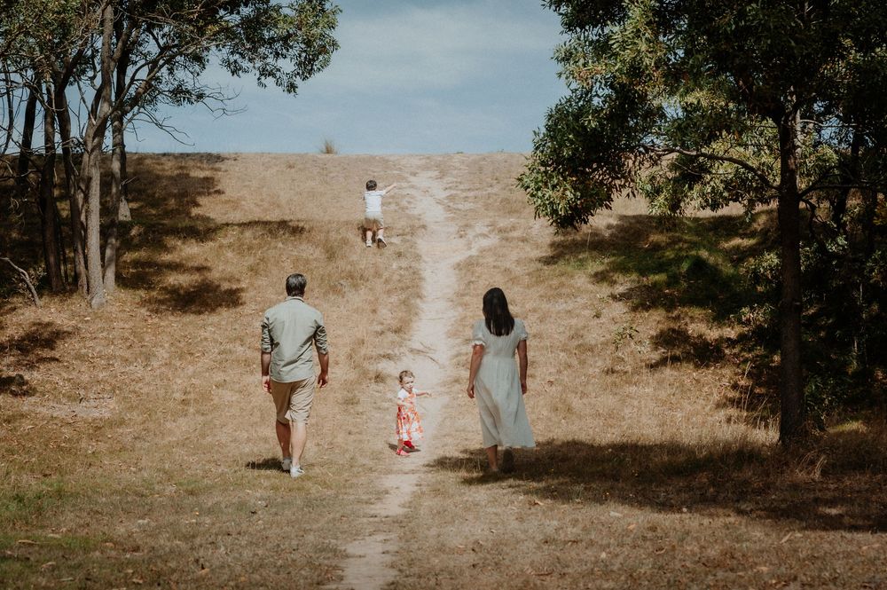 Family walking together on a hillside trail surrounded by eucalyptus trees.
Altona Family Photographer Melbourne