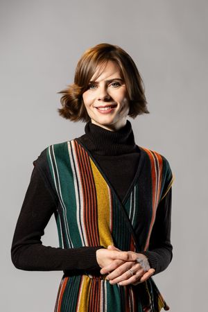 Model poses in black turtleneck and multicolored striped vest showing different expressions and angles.