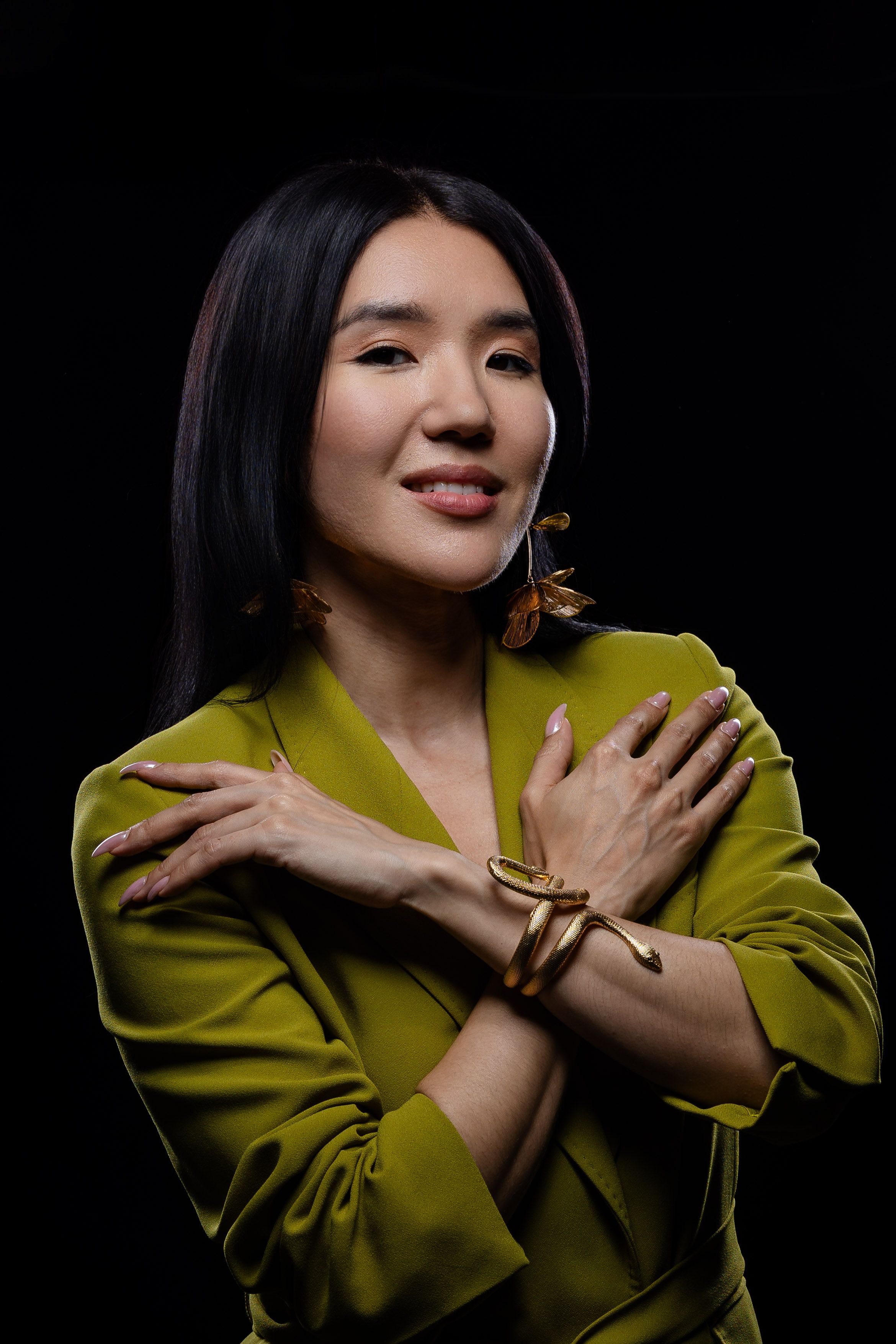 Dramatic portrait series showing poses in chartreuse blazer against black background.