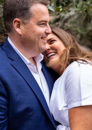 Couple sharing intimate moment outdoors while wearing formal attire.