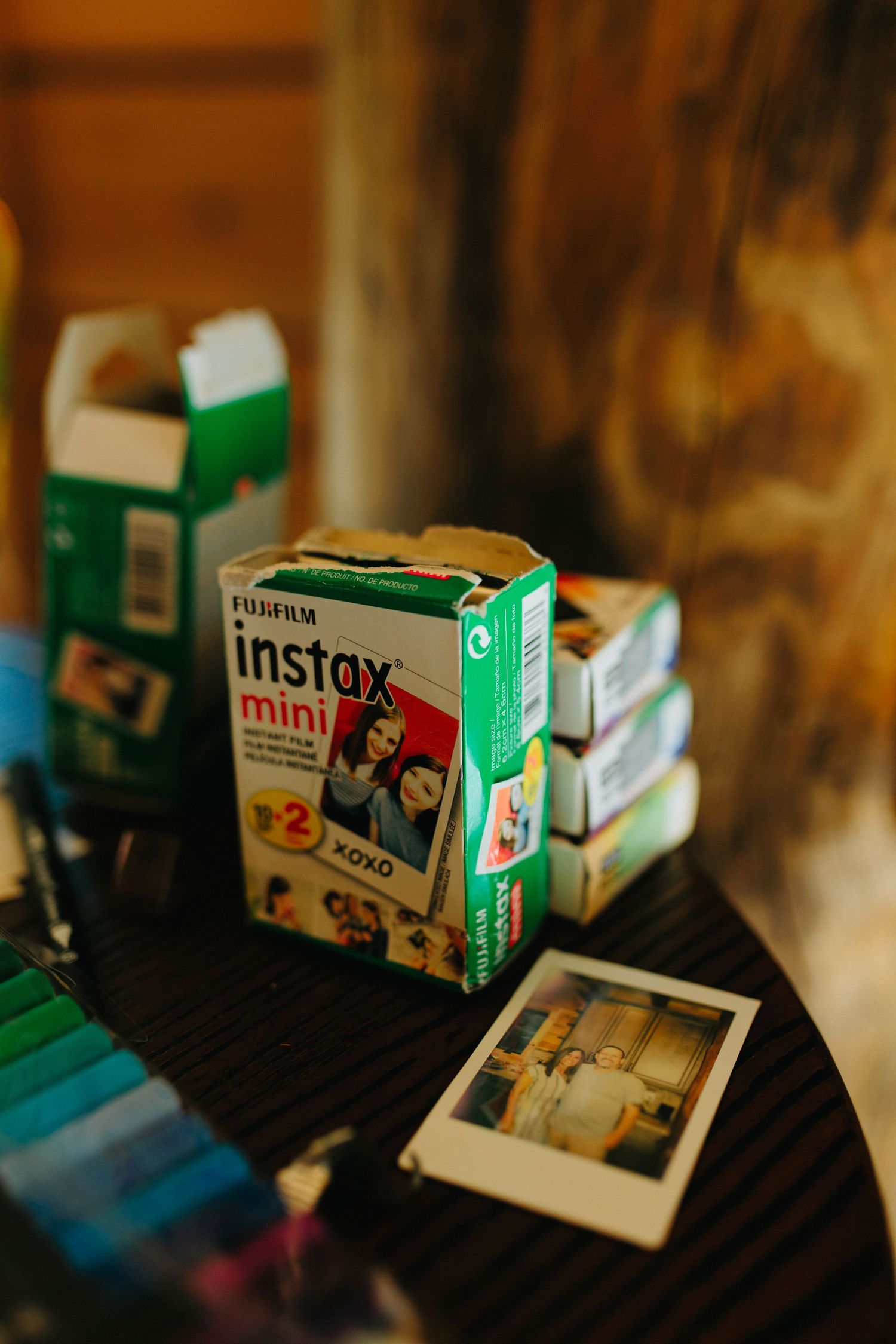 Vintage Fujifilm Instax Mini cameras and film boxes arranged on dark surface.