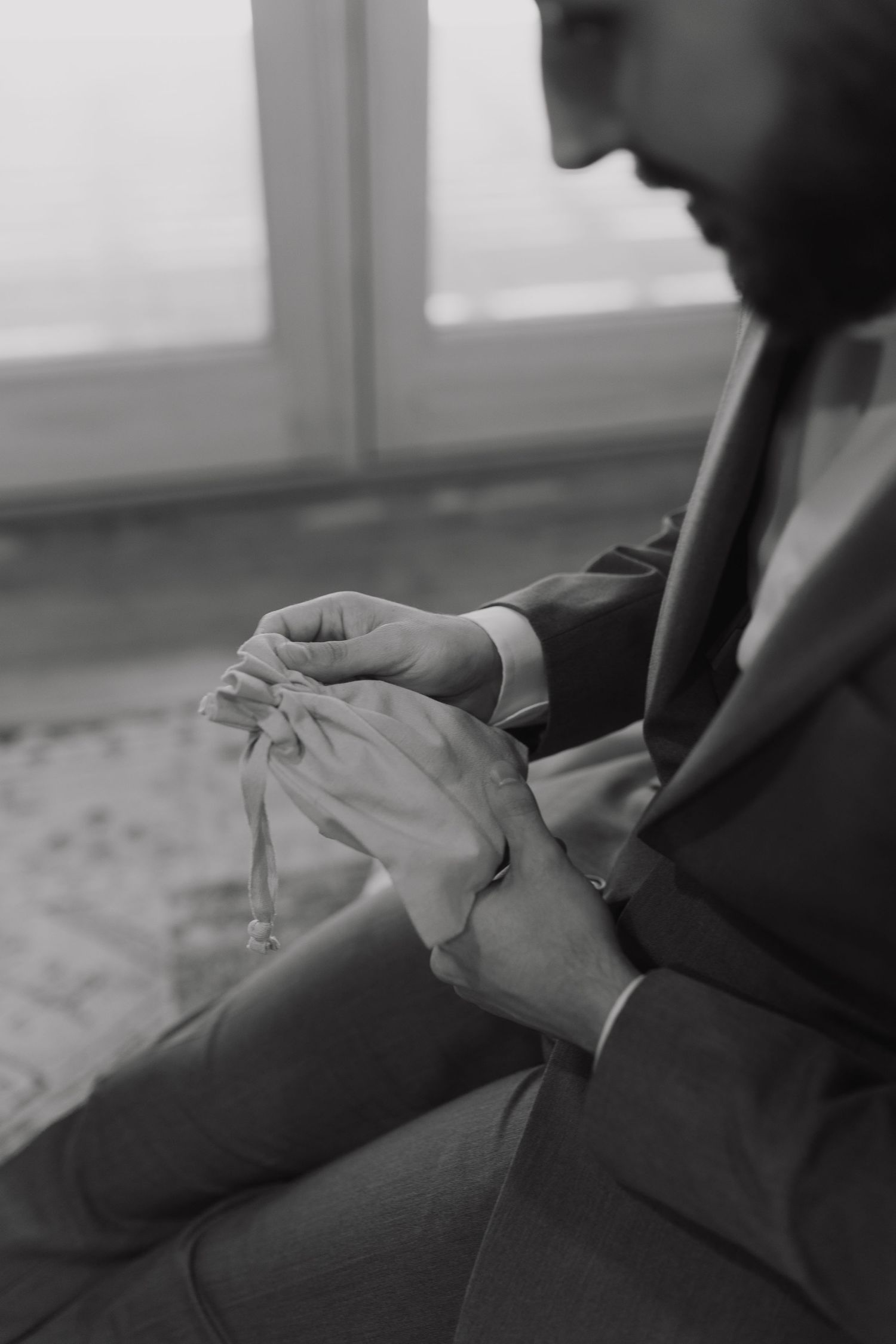 Series of black and white close-up photos showing hands nervously fidgeting on dark fabric.