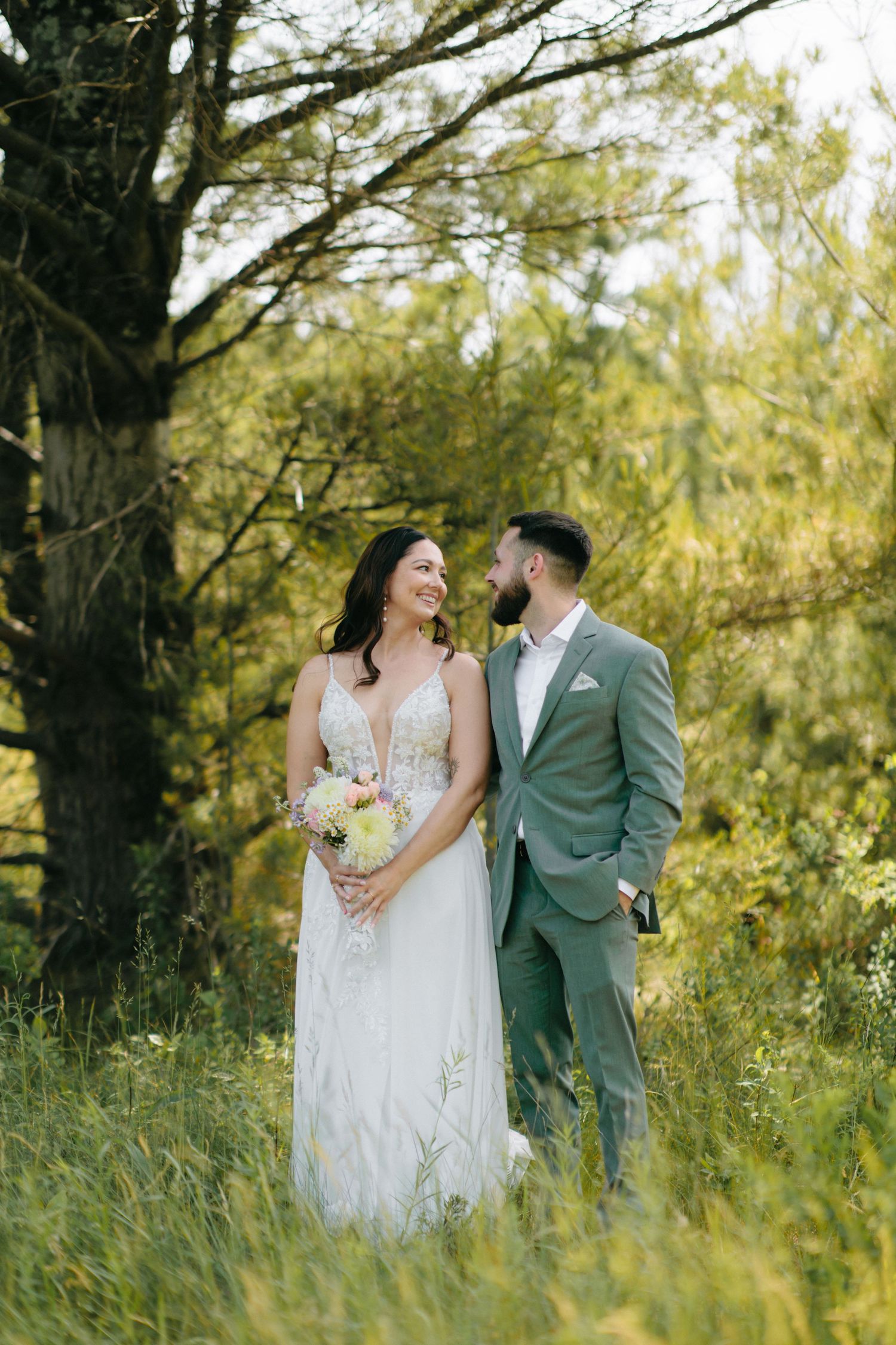 A couple shares intimate moments in a lush outdoor setting with natural lighting.