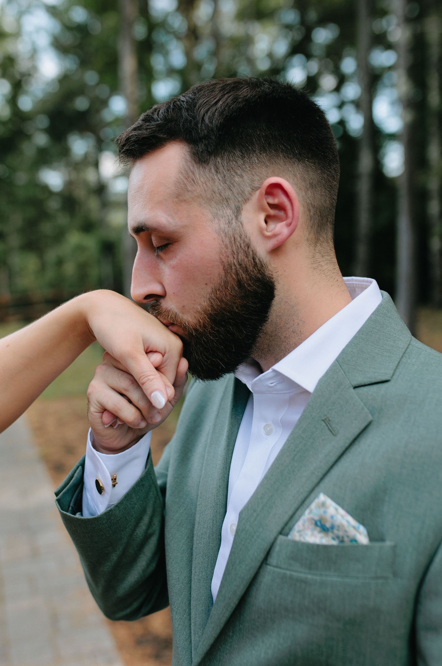 A sequence of four candid emotional moments showing someone in a sage green suit and white dress shirt.