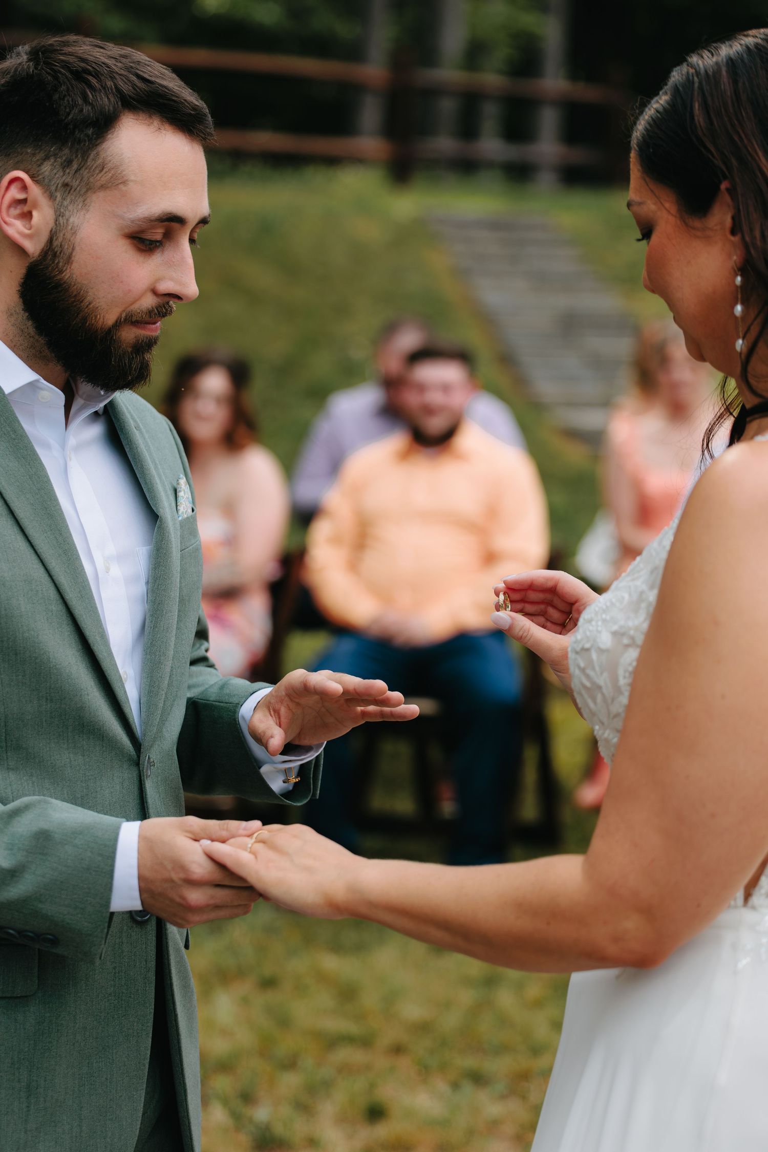 Closeup sequence of couple exchanging wedding rings during outdoor ceremony.