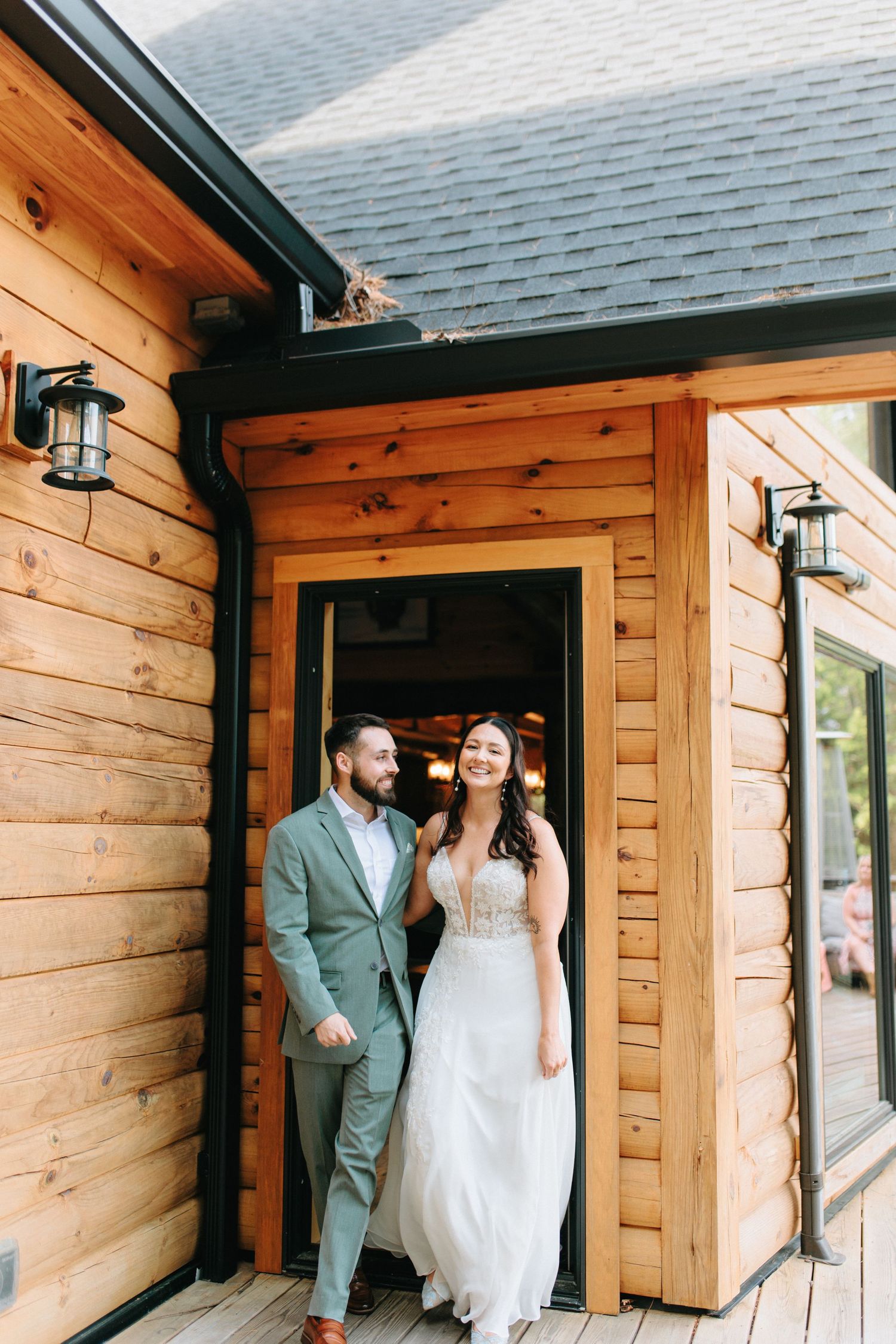 A rustic wooden cabin entrance with exterior lantern lights and gray shingled roof visible above.