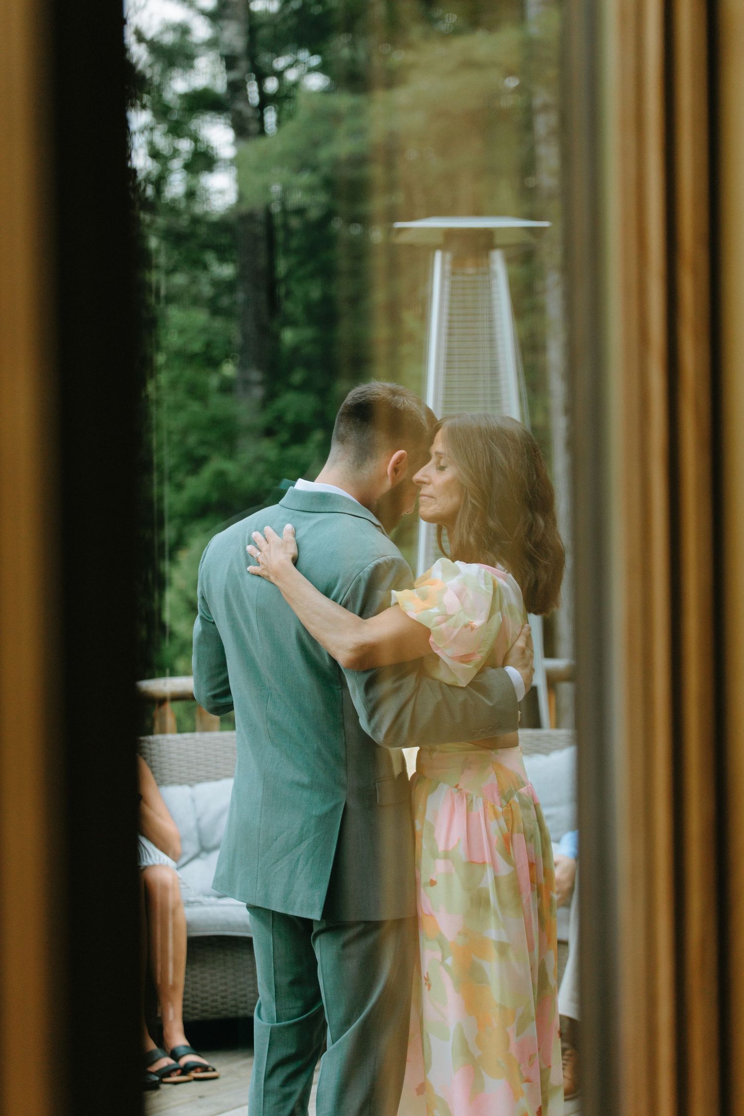 A couple dancing together in an elegant indoor setting with large windows.
