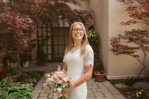 An elegant bridal portrait session against a stone wall with Japanese maple trees and stone pathways.