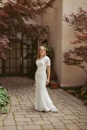 A serene bridal portrait session in a courtyard featuring stone pathways and Japanese maple trees.