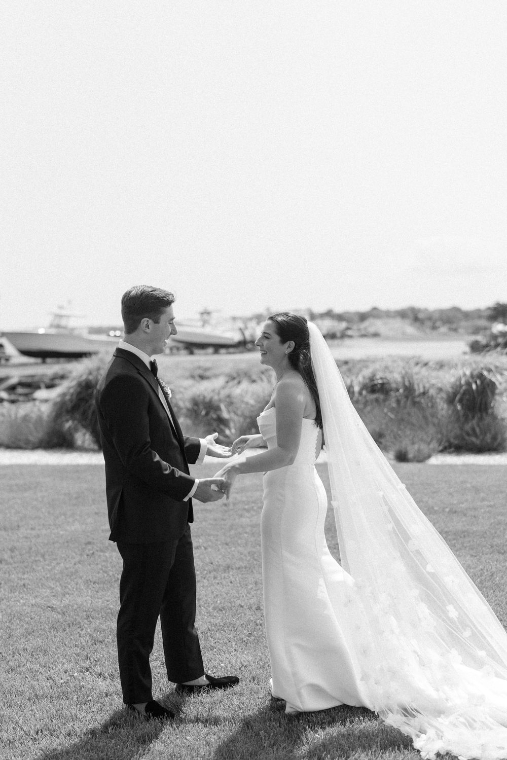 A black and white photo captures a tender wedding moment on an outdoor lawn.