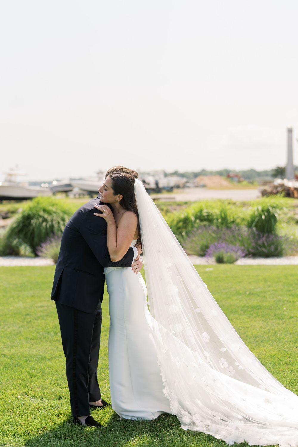A romantic wedding moment captured on a scenic lawn with a flowing white veil.