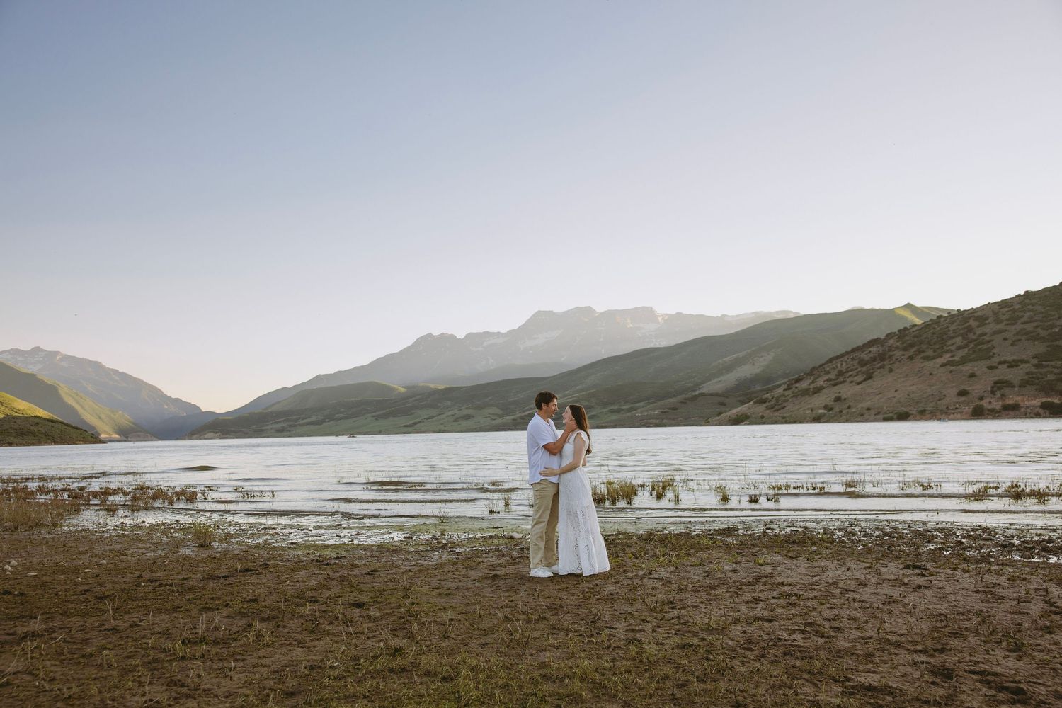 A scenic mountain vista with snow-capped peaks reflecting in a peaceful lake at sunset.