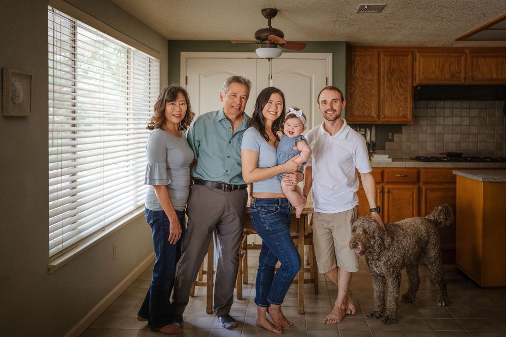 A wide angle view of a family spending time together in their sunlit kitchen space.