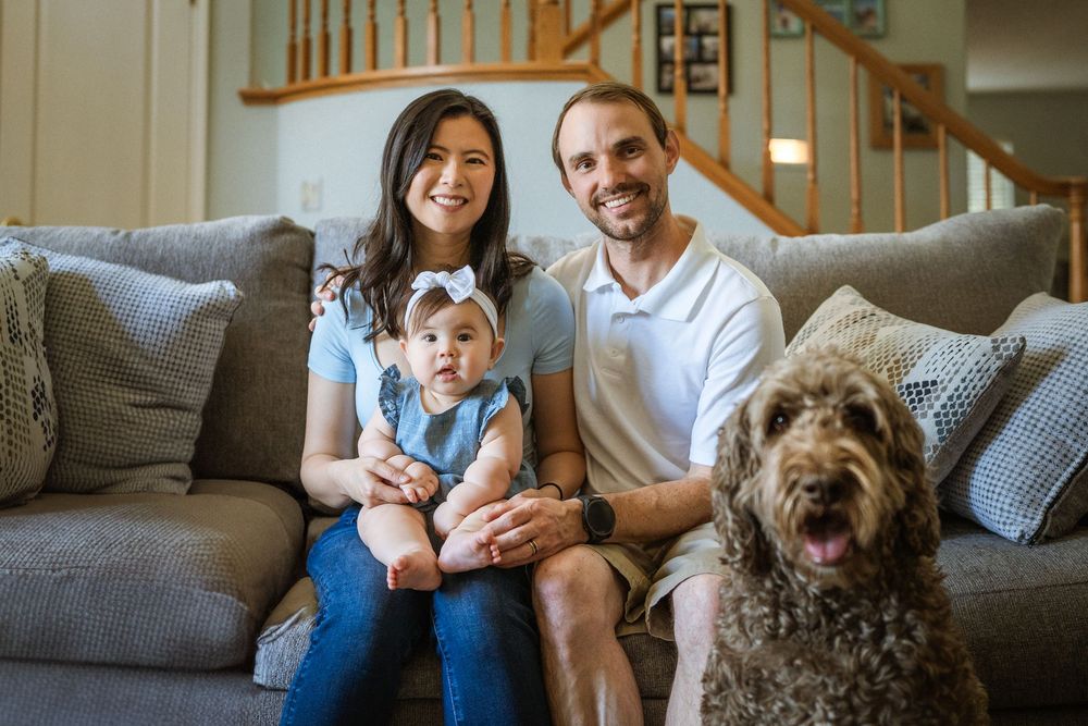 Casual family scene on a comfortable grey sofa with their pet dog.