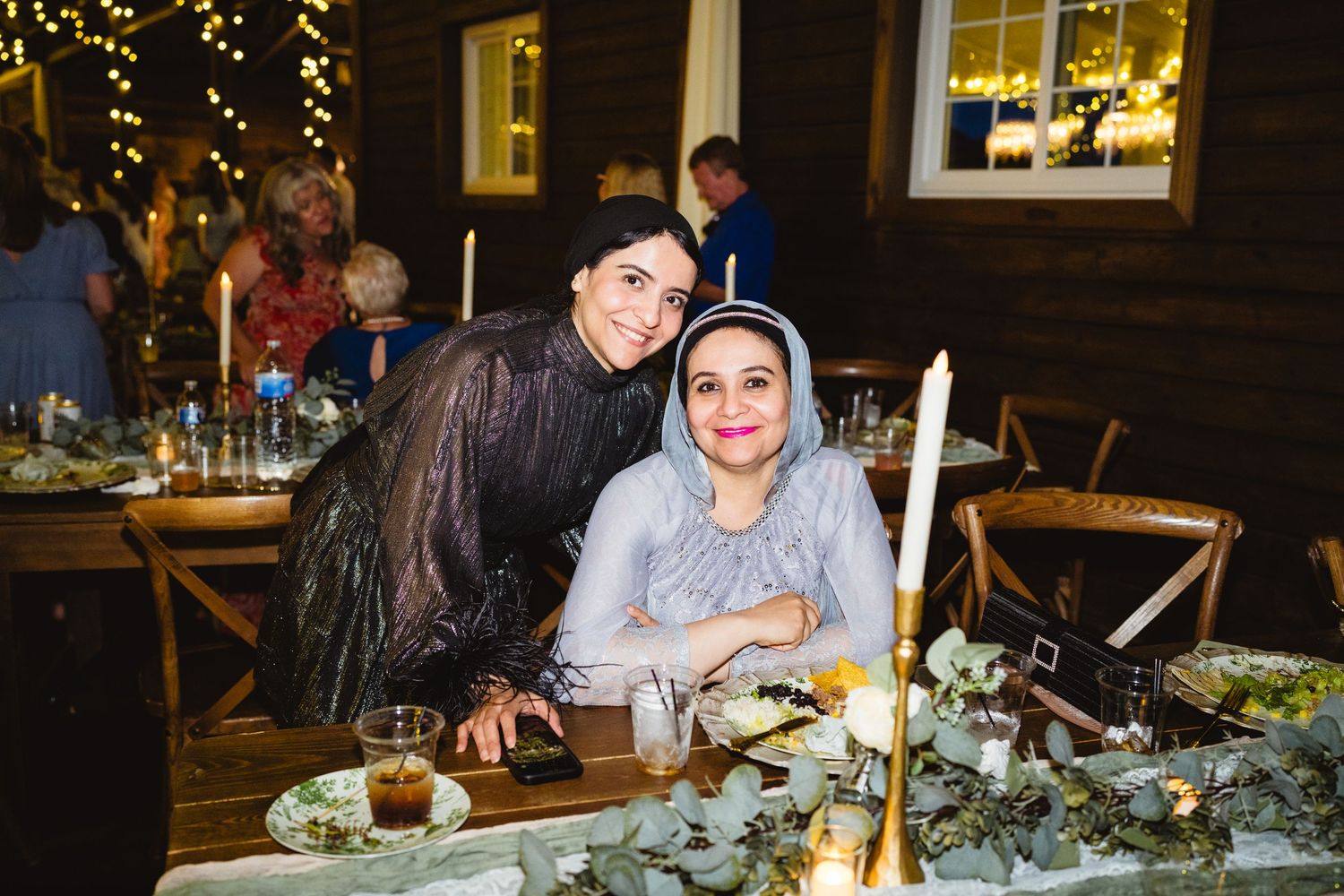 Wedding celebration at rustic venue with elegant table decorations and warm lighting.