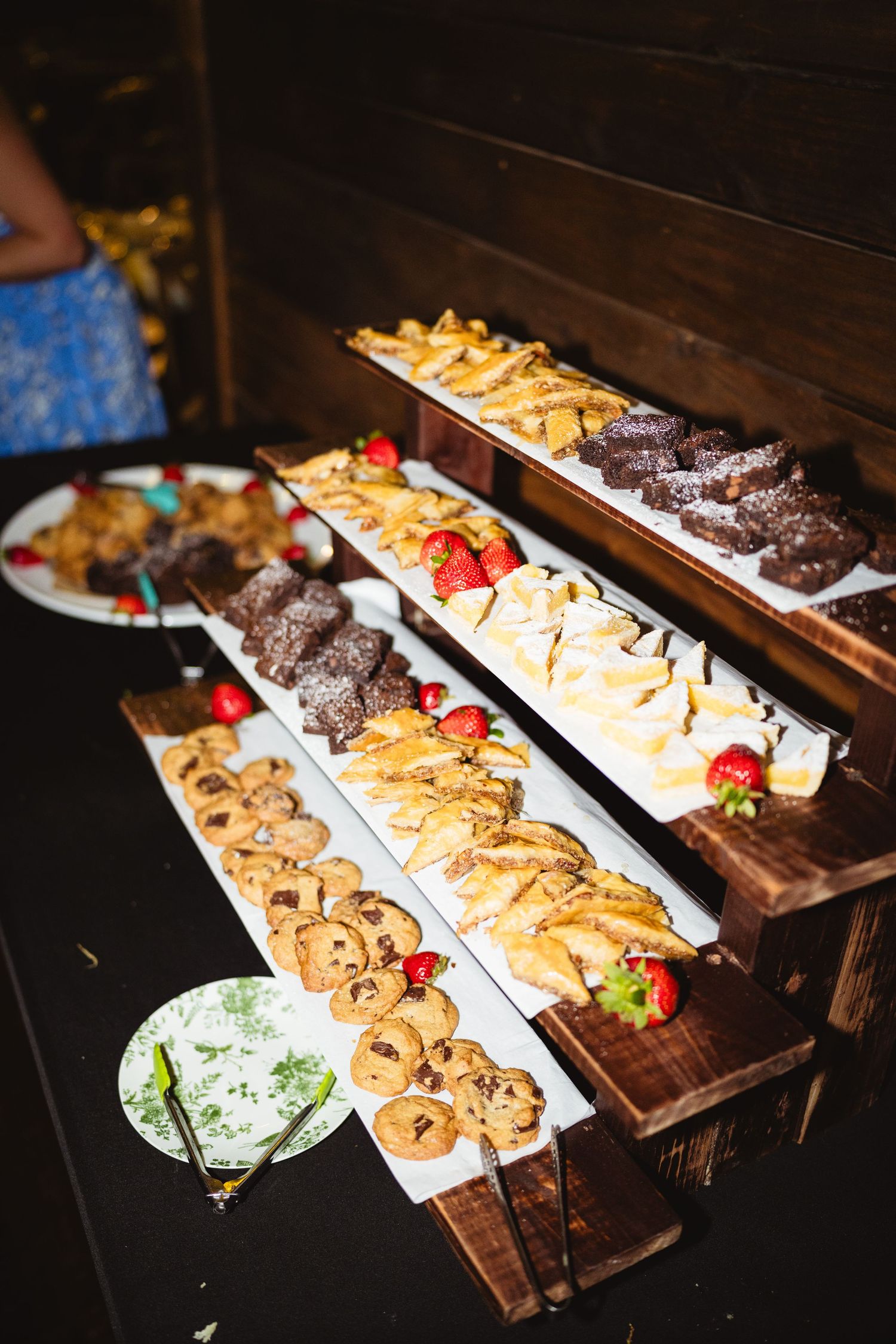 Dessert display featuring chocolate truffles and pastries arranged on wooden serving boards at an elegant event.