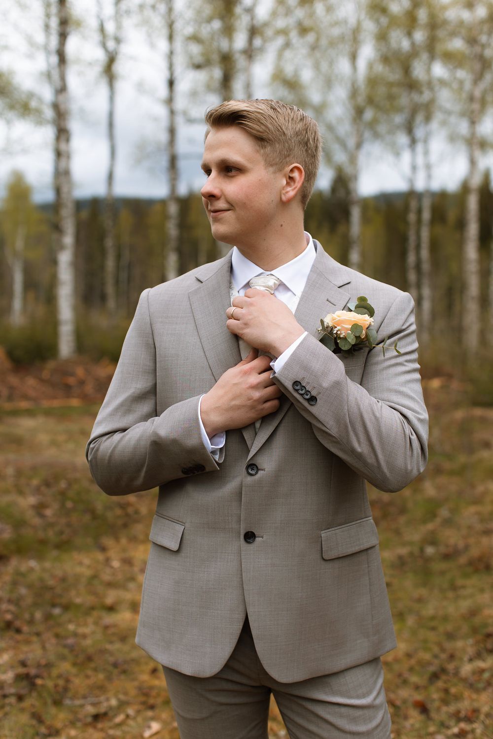 Brudgum som knyter slipsen.