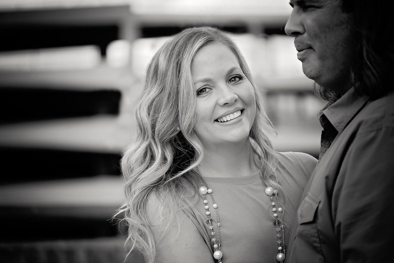 Black and white photo series showing a romantic couple embracing and smiling in an intimate outdoor setting.