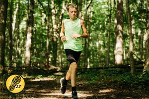 Trail runners navigate a shaded forest path during a summer training workout in the woods.