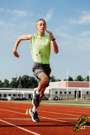 Athlete wearing yellow tank top performing dynamic running drills on red track surface during training session.