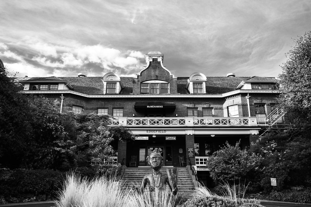 Black and white architectural photograph of a historic mansion with dormers and grand entrance.