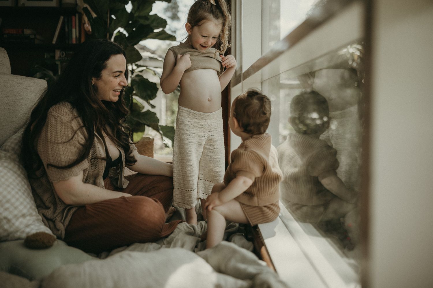 A dark moody collection of candid photographs showing gentle moments between children and nature in natural light.