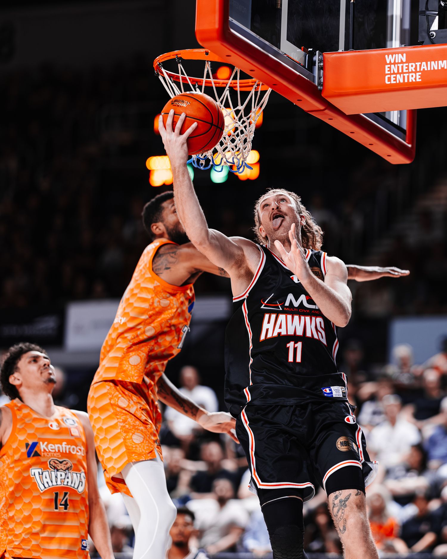 Basketball action shots showing players competing for rebounds and layups during a game.